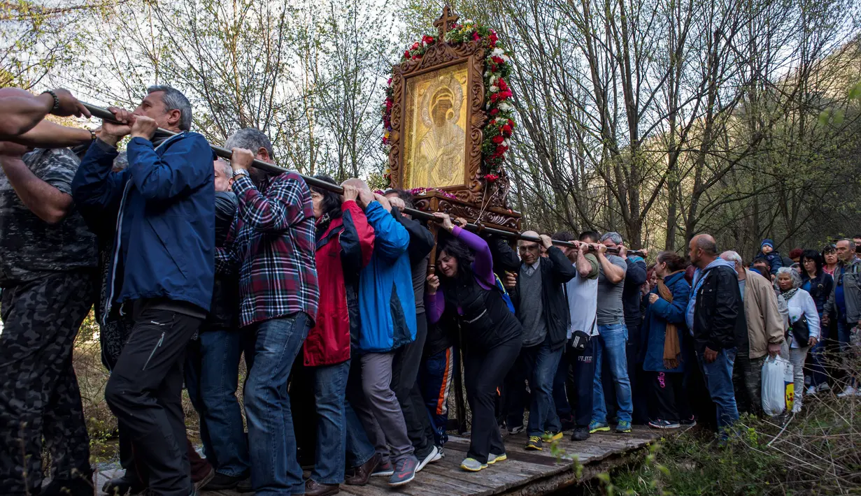Jemaat Kristen Ortodoks menggotong simbol Perawan Maria selama prosesi keagamaan tahunan di Biara Bachkovo, Bulgaria (9/4). Prosesi ini digelar setiap tahun pada hari kedua Paskah Ortodoks. (AFP Photo/Nikolay Doychinov)