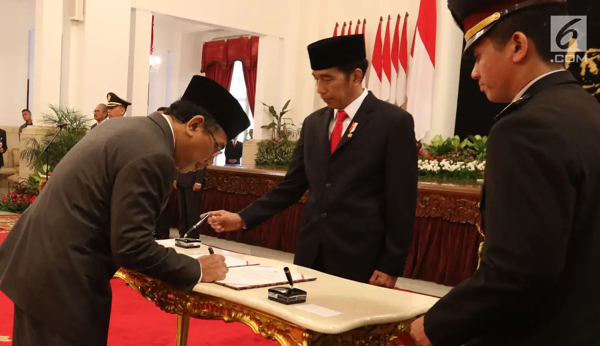 Khatib Aam PBNU Yahya Cholil Staquf menandatangani dokumen disaksikan Presiden Joko Widodo usai dilantik menjadi anggota Wantimpres menggantikan almarhum KH Hasyim Muzadi yang wafat. (liputan6.com/Angga Yuniar)