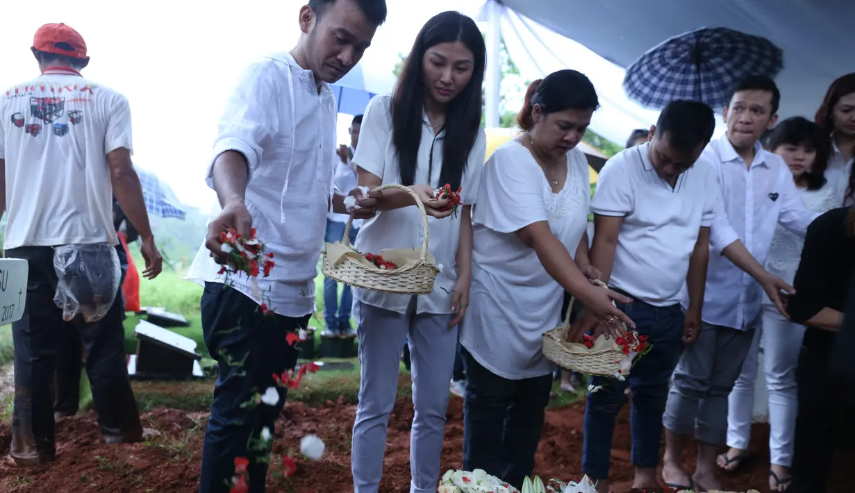 Tangis Ruben kembali pecah saat ayahnya telah rata dengan tanah dan bertabur bunga. Sambil terus memegangi tanda salib yang bertuliskan nama, Ruben tak henti-hentinya menangis. (Nurwahyunan/Bintang.com)