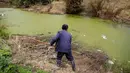 Seorang petani berada di dekat sungai tercemar di Shanghai, Tiongkok pada 21 Maret 2016. Pertumbuhan industri dan penegakan hukum yang rendah terhadap pelaku pencemaran lingkungan membuat saluran air terkontaminasi. (REUTERS / Aly Lagu)