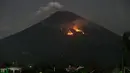Api membakar hutan lereng Gunung Agung setelah terjadinya lontaran batu pijar dari kawah terlihat dari Karangasem, Bali, Selasa (3/7). Lontaran lava pijar pun teramati keluar kawah dengan jarak mencapai 2 ribu meter. (AP/Firdia Lisnawati)