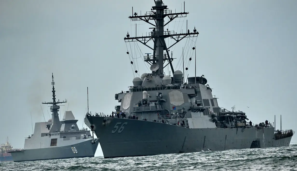Kapal perang USS John S. McCain milik Angkatan Laut AS (kanan) dikawal kapal selam Singapura RSS Intrepid (kiri) menuju pangkalan angkatan laut Changi di Singapura, Senin (21/8). (AFP Photo/Roslan Rahman)