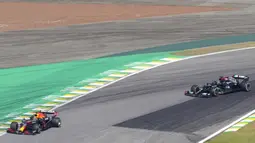 Pembalap Red Bull Max Verstappen (kiri) mengemudikan mobilnya diikuti pembalap Mercedes Lewis Hamilton pada Formula 1 Grand Prix di Sirkuit Interlagos, Sao Paulo, Brasil, 14 November 2021. Lewis Hamilton di urutan pertama, Max Verstappen kedua, dan Valtteri Bottas ketiga. (AP Photo/Andre Penner)