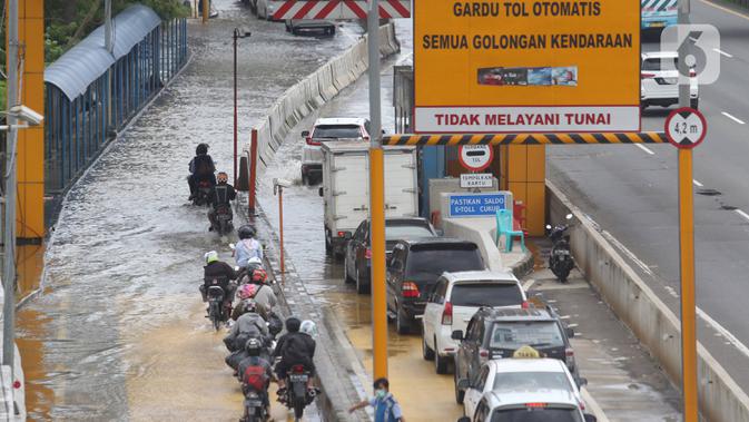 Sejumlah kendaraan melintasi Gerbang Tol Karang Tengah Barat 2 yang masih terendam banjir, Tangerang, Banten, Kamis (2/1/2020). Banjir setinggi betis orang dewasa masih menggenangi Gerbang Tol Karang Tengah Barat 2. (Liputan6.com/Angga Yuniar)
