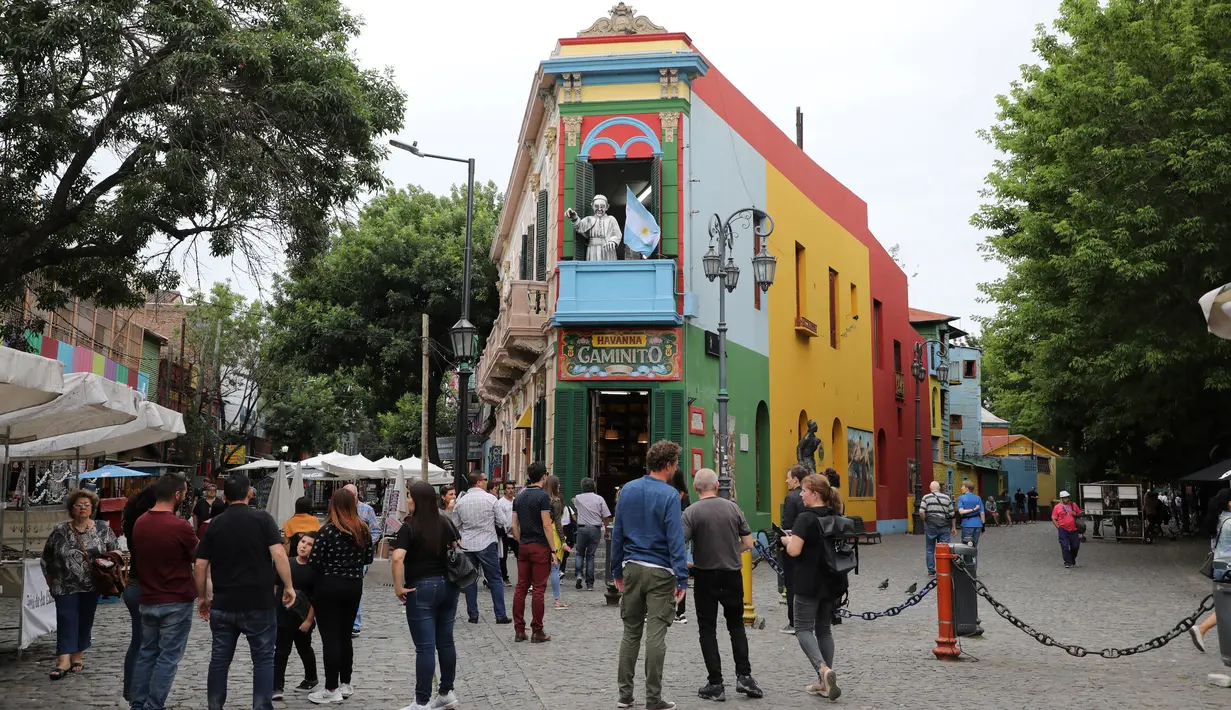 Wisawatan mengunjungi lingkungan La Boca, ibu kota Argentina, Buenos Aires pada 27 November 2018. Bangunan di daerah ini sangat berwarna dengan berbagai warna cerah seperti melihat pelangi. (Ludovic MARIN / AFP)