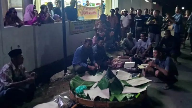 Warga Remen Tuban menggelar tumpeng menolak adanya minimarket di wilayahnya. (Adirin/Liputan6.com)