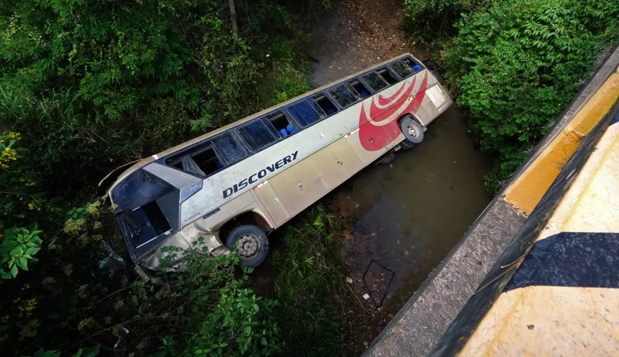 Gambar bus yang terjun ke sungai dangkal dekat Tegucigalpa, Honduras, Selasa (5/12/2023). Kecelakaan menewaskan 13 orang dan melukai puluhan lainnya. (Johny MAGALLANES/AFP)