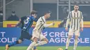 Penyerang Juventus,  Cristiano Ronaldo membawa bola dari kejaran gelandang Inter Milan, Nicolo Barella pada pertandingan lanjutan Liga Serie A Italia di stadion San Siro di Milan, Senin (18/1/2021). Dengan kemenangan ini, Inter menempel AC Milan di puncak klasemen. (AFP/Miguel Medina)