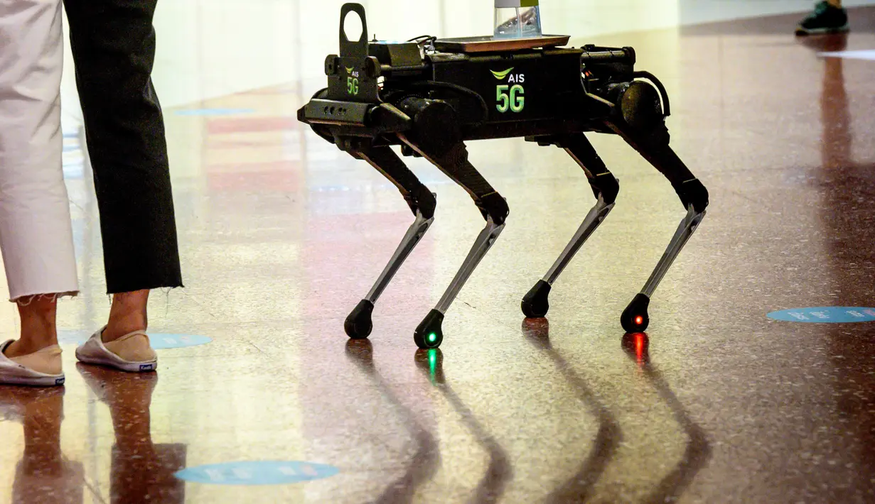 Robot 5G K9 memberikan hand sanitiser atau cairan pembersih tangan kepada pengunjung di pusat perbelanjaan di Bangkok, Kamis (4/6/2020). Saat ini Thailand sedang dalam proses membuka kembali pusat perbelanjaan setelah sebelumnya ditutup selama dua bulan karena pandemi Covid-19 (Mladen ANTONOV / AFP)