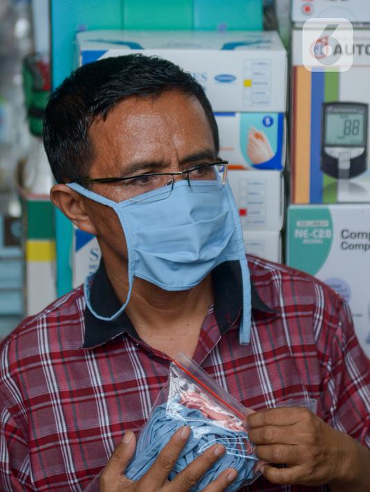 Seorang pria membawa sebungkus masker di Pasar Pramuka, Jakarta Timur, Rabu (4/3/2020). Polda Metro Jaya menggelar sidak di Pasar Pramuka untuk menyikapi lonjakan harga dan kelangkaan masker di pasaran terkait virus corona atau COVID-19. (merdeka.com/Imam Buhori)