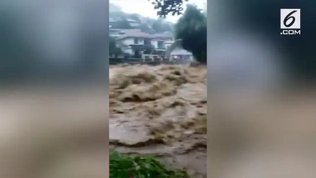 Seorang warga merekam banjir yang melanda Cipayung, Puncak, Bogor. Derasnya air telah memasuki rumah warga