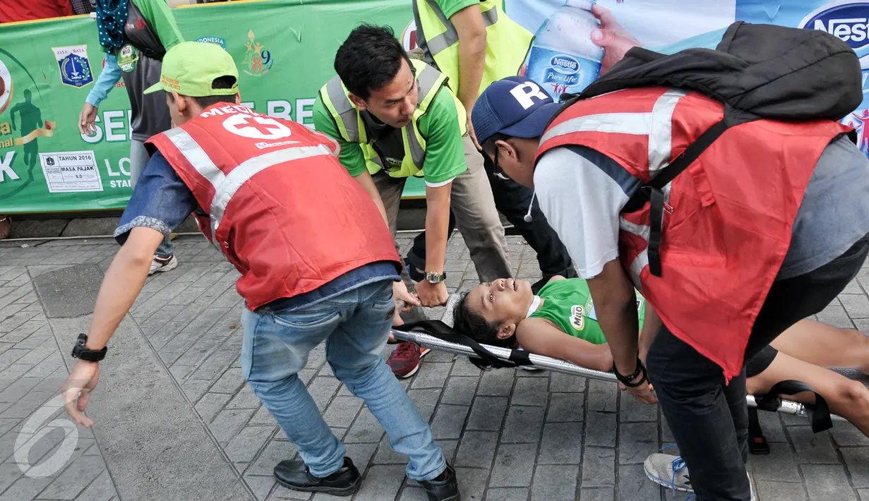 Seorang peserta ditandu usai kelelahan mengikuti lomba lari 'Milo Jakarta International 10K' di kawasan Kuningan, Jakarta, Minggu (24/7). Lomba lari itu dibula langsung oleh Wakil Gubernur DKI Jakarta, Djarot Saiful Hidayat. (Liputan6.com/Yoppy Renato)
