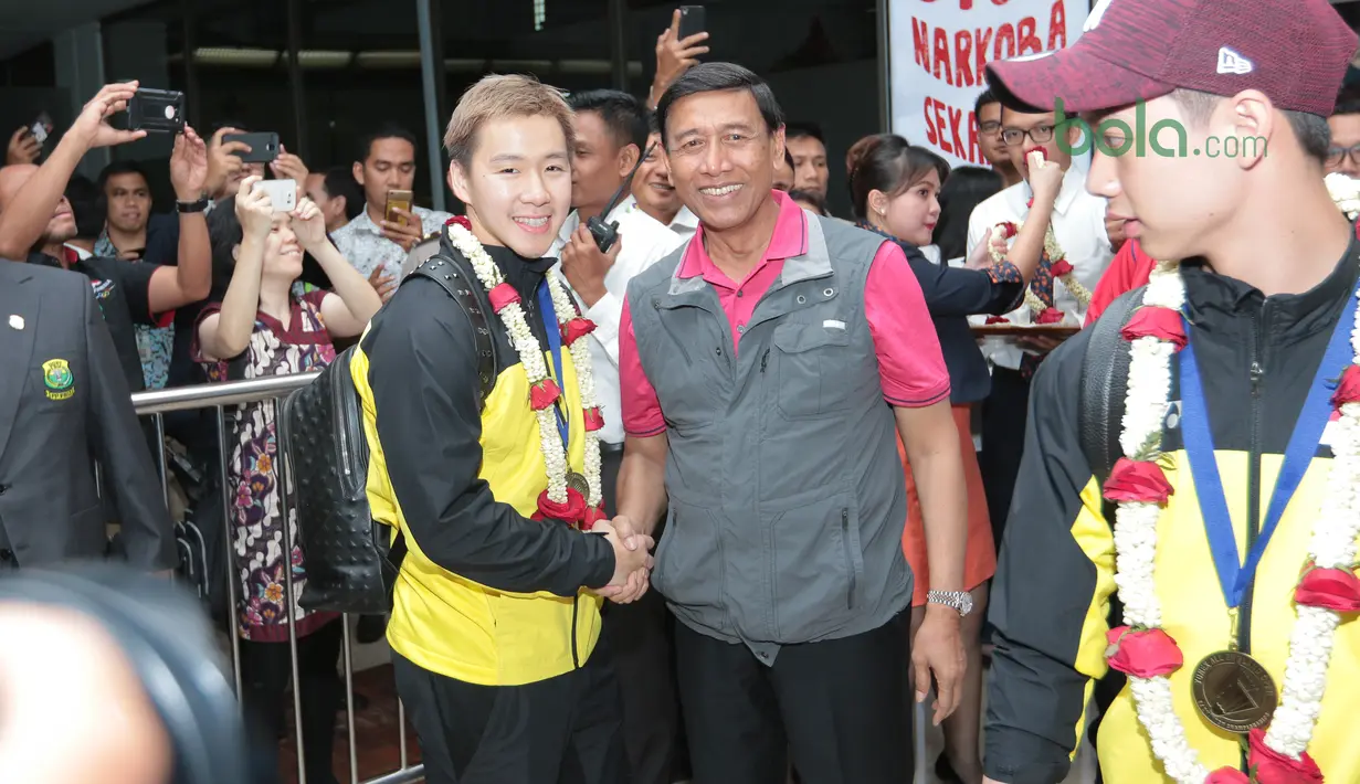 Marcus Gideon bersalaman dengan Ktum PBSI, Wiranto saat tiba di Bandara Soekarno-Hatta, Cengkareng, (20/3/2018). Kevin/Marcus mampu mempertahankan gelar All England 2018. (Bola.com/Nick Hanoatubun)