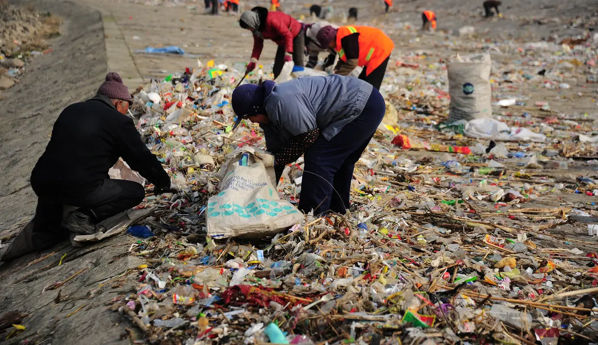 Warga memilah sampah di sekitar Sungai Yangtze, Taicang, Jiangsu, Tiongkok (23/12). Pulau yang berada dekat Shanghai ini berubah menjadi lautan sampah yang diperkirakan mencapai 100 ton. (REUTERS/Stringer)