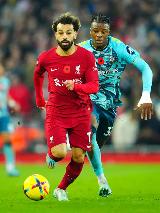 Pemain Liverpool Mohamed Salah (kiri) menggiring bola meninggalkan pemain Southampton Armel Bella-Kotchap pada pertandingan sepak bola Liga Inggris di Stadion Anfield, Liverpool, Inggris, 12 November 2022. Liverpool mengalahkan Southampton dengan skor 3-1. (AP Photo/Jon Super)