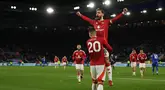 Gelandang Manchester United, Bruno Fernandes melompat ke pelukan Diogo Dalot saat merayakan gol ketiga mereka pada pertandingan pekan ke-29 Premier League 2024/2025 melawan Leicester City di King Power Stadium, Inggris pada 16 Maret 2025 waktu setempat atau Senin (17/3/2025) dini hari WIB. (Adrian Dennis/AFP)