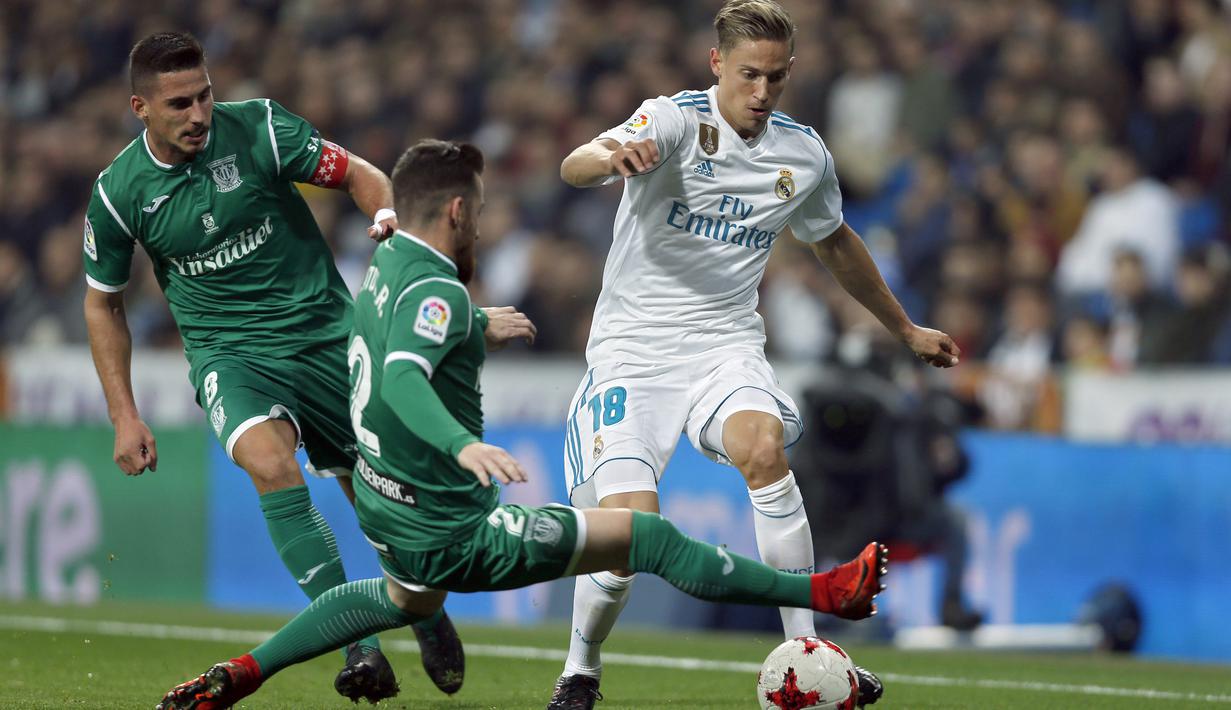 Pemain Real Madrid, Marcos Llorente (kanan) mengecoh dua pemain Leganes pada perempat final Copa del Rey di Santiago Bernabeu stadium, Madrid, (24/1/2018). Leganes menang 2-1. (AP/Francisco Seco)