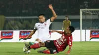 Gelandang Bali United, Muhammad Taufiq, berebut bola dengan gelandang Madura United, Guntur Ariyadi, pada laga Liga 1 2019 di Stadion Kapten I Wayan Dipta, Bali, Minggu (22/12). Bali kalah 0-2 dari Madura. (Bola.com/Aditya Wany)