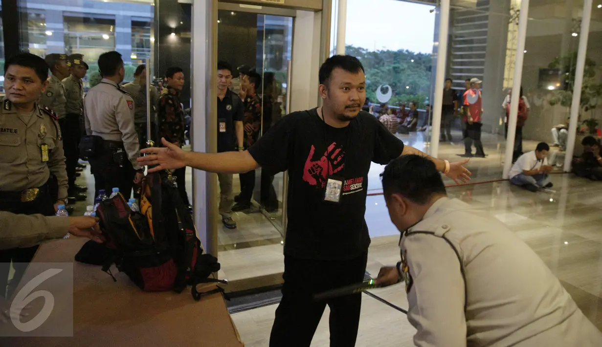 Seorang pengunjung diperiksa petugas polisi sebelum memasuki tempat Debat terakhir Pilgub DKI Jakarta 2017, Jakarta, Rabu (12/4). Tema debat terakhir Pilgub DKI adalah 'Dari Masyarakat Jakarta untuk Jakarta'. (Liputan6.com/Faizal Fanani)