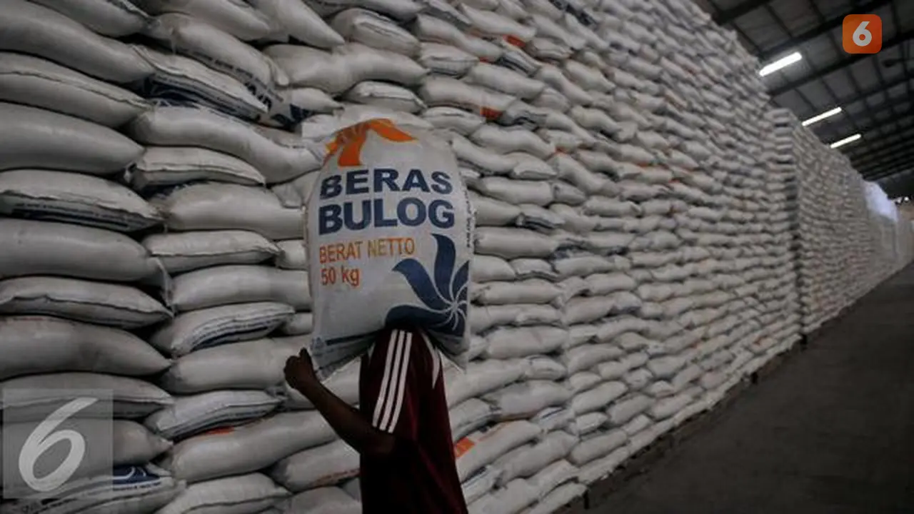 Pekerja memanggul karung Beras milik Badan Urusan Logistik (Bulog) di Gudang Bulog kawasan Kelapa Gading, Jakarta Utara, Selasa (7/6). Bulog memiliki stok beras sebanyak 2,1 juta ton. (Liputan6.com/Johan Tallo)