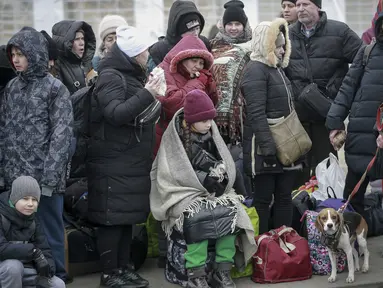 Orang-orang yang meninggalkan Ukraina menunggu bus untuk menuju stasiun kereta api di Przemysl, di perbatasan di Medyka, Polandia, Jumat (4/3/2022). PBB pada Kamis (3/3) melaporkan 1 juta orang telah meninggalkan Ukraina sejak invasi Rusia terhadap negara itu sepekan lalu. (AP Photo/Visar Kryeziu)
