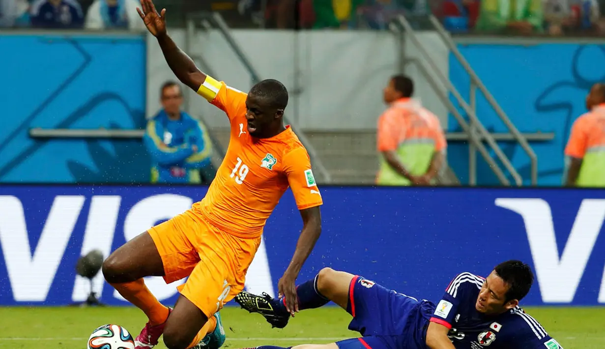 Pemain belakang Jepang, Maya Yoshida, berjibaku menahan laju serangan Yaya Toure (Pantai Gading - kanan) saat berlaga di penyisihan Piala Dunia 2014 Grup C di Pernambuco Arena, Recife, Brasil, (15/6/2014). (REUTERS/Yves Herman)