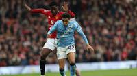 Gelandang Manchester United asal Inggris bernomor punggung 37, Kobbie Mainoo, berduel dengan bek Manchester City asal Inggris bernomor punggung 82, Rico Lewis, selama pertandingan Liga Inggris antara Manchester United dan Manchester City di Old Trafford, Manchester, barat laut Inggris, pada 17 Januari 2026. (Darren Staples/AFP)