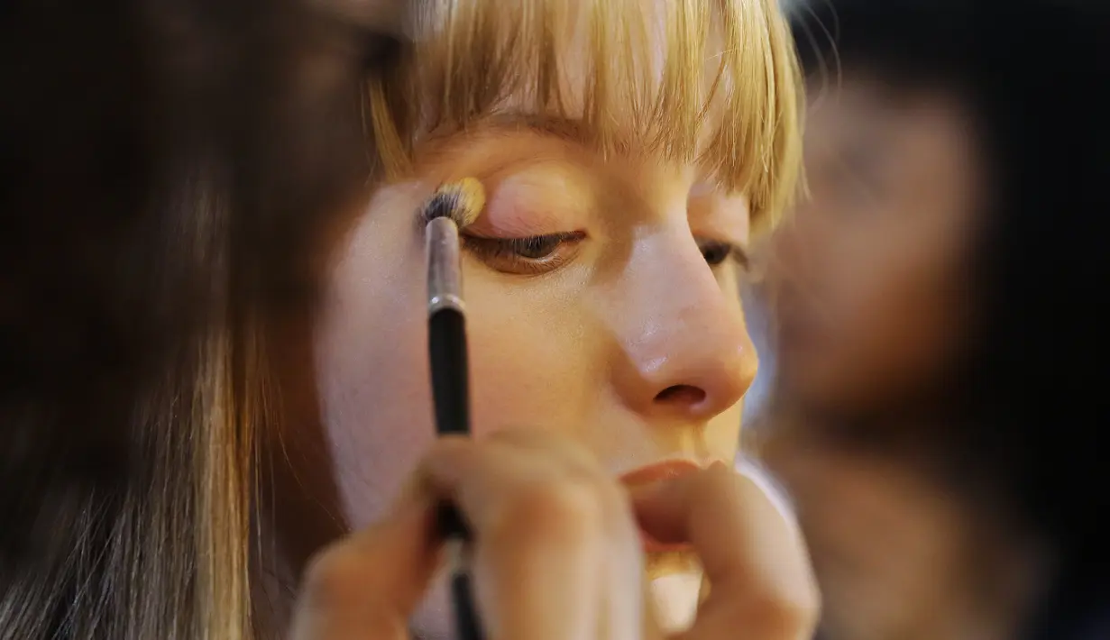 Model saat dirias wajahnya di belakang panggung sebelum tampil membawakan busana koleksi Beira selama Sao Paulo Fashion Week di Sao Paulo, Brasil (16/10/2019). SPFW ke-48 akan berlangsung hingga 18 Oktober.  (AP Photo / Nelson Antoine)