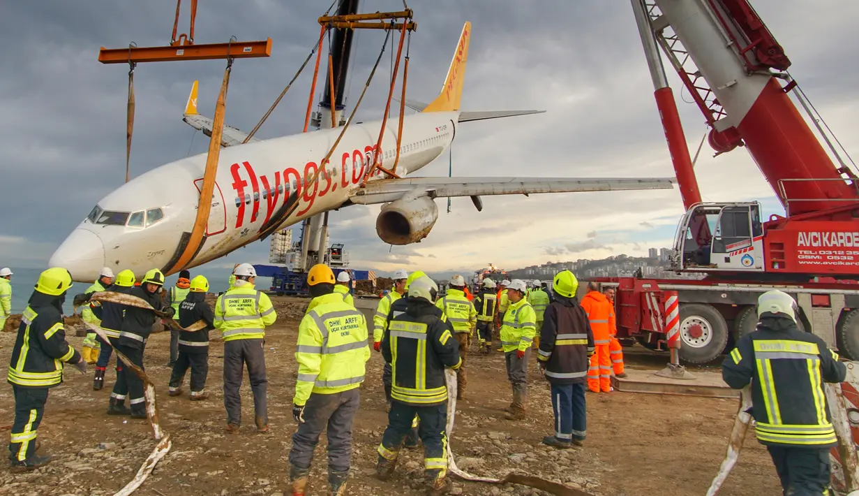 Petugas mengevakuasi pesawat Boeing 737-800 dari maskapai Pegasus Airlines yang nyaris terperosok ke dalam laut di bandara Trabzon, Turki (18/1). Dalam insiden tersebut seluruh penumpang dan awak selamat. (AP Photo / Turkay Albayak)