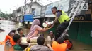 Petugas membantu mengevakuasi bayi yang terjebak banjir di perumahan Ciledug Indah, Tangerang, Rabu (1/1/2020). Banjir setinggi dada orang dewasa terjadi akibat meluapnya kali angke. (Liputan6.com/Angga Yuniar)