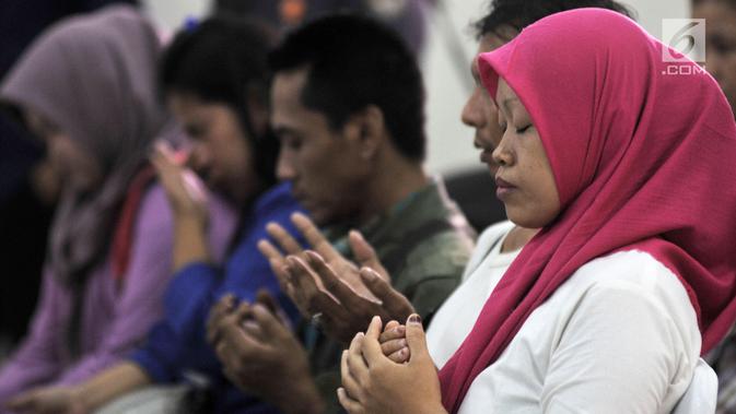 Istri almarhum Ketua KPPS Bekasi Masnun memanjatkan doa saat acara Ngopi Bareng Ombudsman di Ruang Serbaguna Ombudsman RI, Jakarta, Selasa (30/4/2019). (merdeka.com/Iqbal Nugroho)