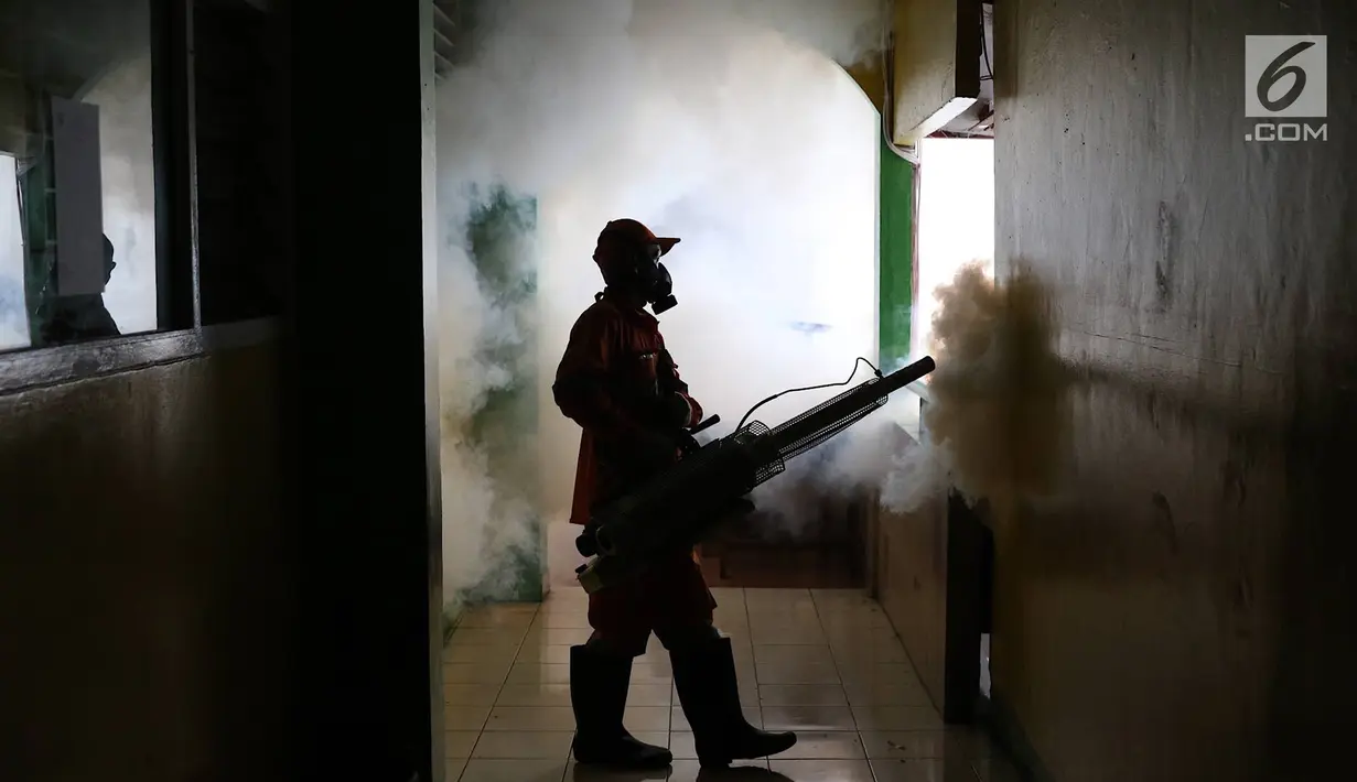 Petugas melakukan pengasapan (fogging) di sebuah sekolah di kawasan Kebon Baru, Tebet, Jakarta, Kamis (28/2). Pengasapan dilakukan terkait adanya warga di kawasan tersebut yang terkena penyakit demam berdarah. (Liputan6.com/Immanuel Antonius)
