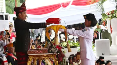 Presiden Jokowi menyerahkan Bendera Merah Putih kepada Fariza Putri Salsabila, anggota Pasukan Pengibar Bendera Pusaka (Paskibraka), saat Upacara Peringatan Detik-detik Proklamasi 17 Agustus di Istana, Jakarta, Kamis (17/8). (Liputan6.com/Pool)
