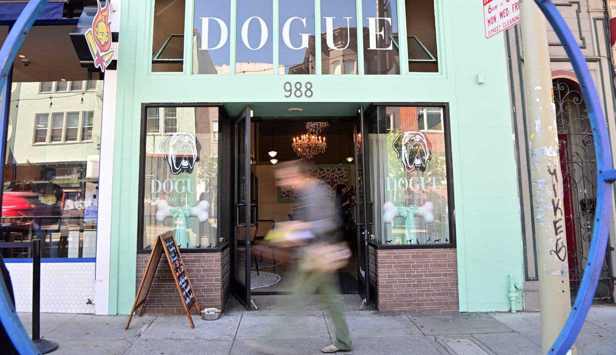 Seorang pria berjalan dekat restoran untuk anjing Dogue di San Francisco, California, Amerika Serikat, 5 Oktober 2022. Restoran Dogue menawarkan menu cicip tiga hidangan seharga USD 75, kue seharga USD 95, filet mignon tartare yang dipotong dengan tangan, dan berbagai makanan lezat lainnya hanya untuk anjing. (JOSH EDELSON/AFP)