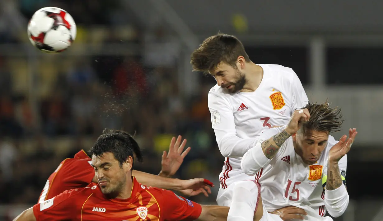 Pemain Spanyol, Gerard Pique menghalau bola dari kejaran pemain Makedonia pada laga kualifikasi Piala Dunia 2018 grup G di Philip II National Stadium, Skopje, MaKedonia, (11/6/2017). (AP/Boris Grdanoski)