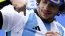 Pebalap Tim Mooney VR46, Marco Bezzecchi menunjukkan jersey Timnas Argentina bertandatangan Lionel Messi saat menjuarai MotoGP Argentina 2023 di Autódromo Termas de Río Hondo, Argentina, Senin (03/04/2023) dini hari WIB. Selebrasi tersebut diketahui meniru sang gurunya, Valentino Rossi yang dilakukan pada musim 2015 silam. (AP Photo/Natacha Pisarenko)