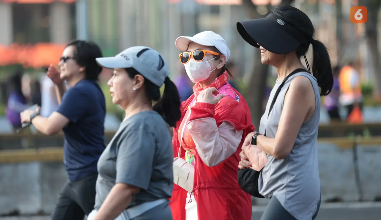 Sejumlah warga memakai masker saat berlari di kawasan Car Free Day (CFD) Jakarta di tengah sebaran abu vulkanik yang berdampak pada kualitas udara. (KLY/Budy Santoso)