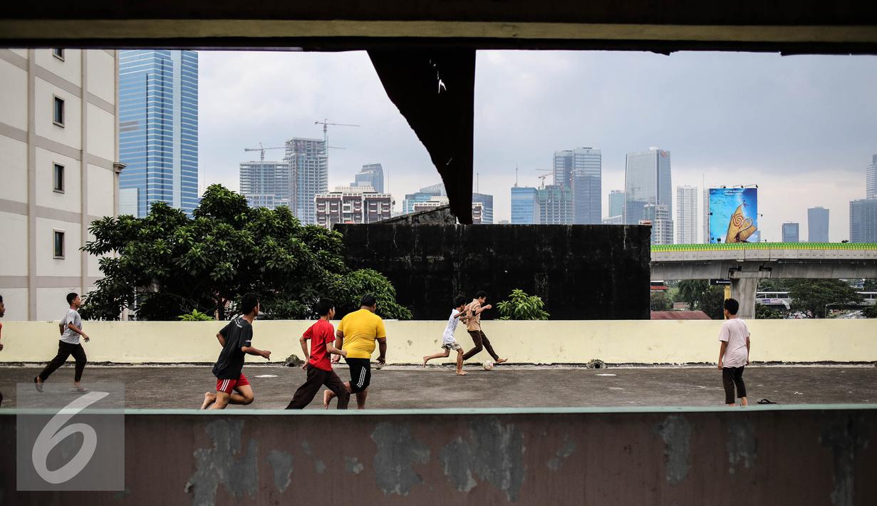 Keseruan saat sejumlah remaja bermain futsal di atas gedung di Pasar Mampang, Jakarta, Rabu (12/7). Karena minimnya lahan, bagian atas Gedung Pasar Mampang ini dimanfaatkan sejumlah remaja tersebut untuk bermain futsal. (Liputan6.com/Faizal Fanani)