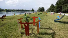 Pemandangan instalasi 'Rainbow Park', oleh desainer dan seniman Stefano Rossetti, di danau buatan Idroscalo, di Milan, Italia, Selasa (22/6/2021). Instalasi yang terdiri dari furnitur jalanan, patung, dan benda logam berwarna, akan dipajang hingga Juni 2022. (AP Photo/Luca Bruno)