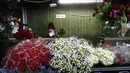 Seorang wanita bekerja di distrik bunga sebelum Hari Valentine di tengah pandemi COVID-19 di Los Angeles, California (12/2/2021). Toko bunga di daerah tersebut sibuk tahun ini dengan pemesanan bunga Hari Valentine dan karangan bunga pemakaman COVID-19. (Mario Tama/Getty Images/AFP)