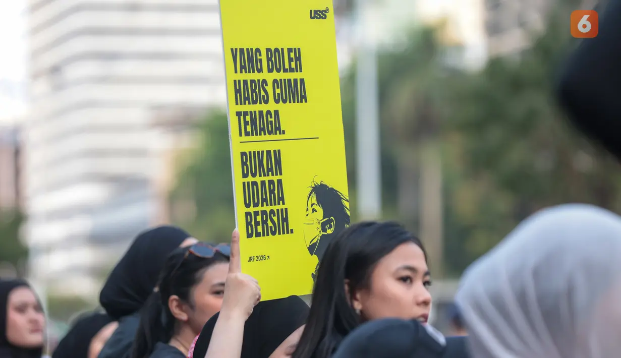 Seorang penonton membawa poster bertema kebakaran hutan dan lahan (karhutla) saat Jakarta Running Festival (JRF) 2026 berlangsung di sepanjang lintasan Jalan Jenderal Sudirman, Jakarta, Sabtu (24/10/2026). (KLY/Budy Santoso)