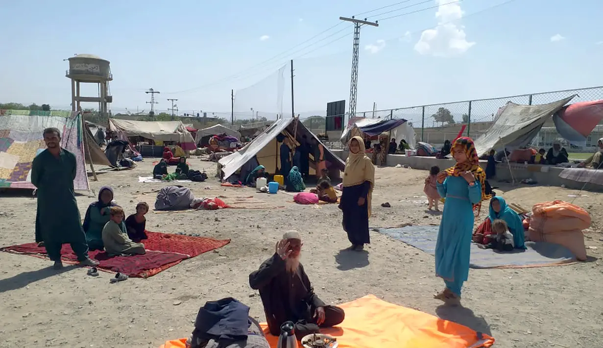Keluarga Afghanistan duduk di luar tenda di area terbuka di pinggiran Chaman, sebuah kota perbatasan di provinsi Baluchistan barat daya Pakistan, Rabu (1/9/2021). Puluhan keluarga Afghanistan telah menyeberang ke Pakistan melalui perbatasan barat daya Chaman sehari setelahnya. (AP Photo/Jafar Khan)