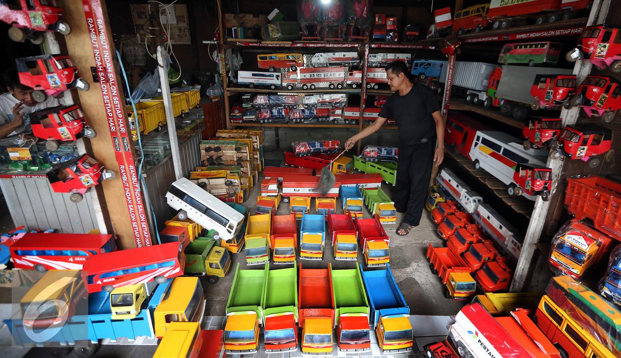 Pedagang mainan kayu membersihkan barang dagangannya di kawasan Kalibata, Jakarta, Selasa (18/10). Mainan kayu tradisional semacam ini masih bertahan oleh gempuran mainan-mainan modern di era digital saat ini. (Liputan6.com/Johan Tallo)