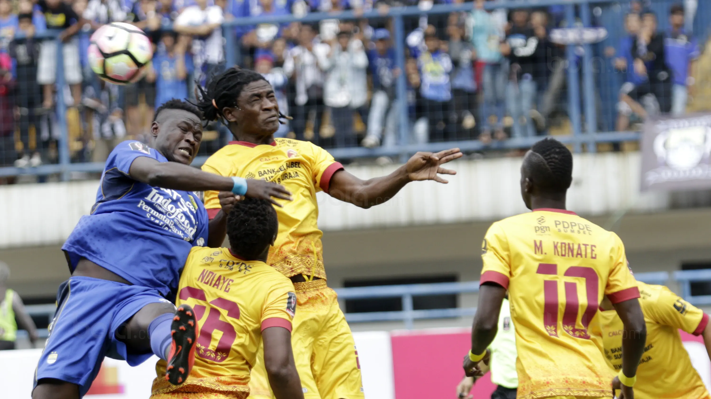 Striker Persib, Ezechiel Ndouassel, duel udara dengan bek Sriwijaya FC, Bio Paulin, pada laga Piala Presiden di Stadion GBLA, Bandung, Selasa (16/1/2018). Sriwijaya FC kalah 0-1. (Bola.com/M Iqbal Ichsan)