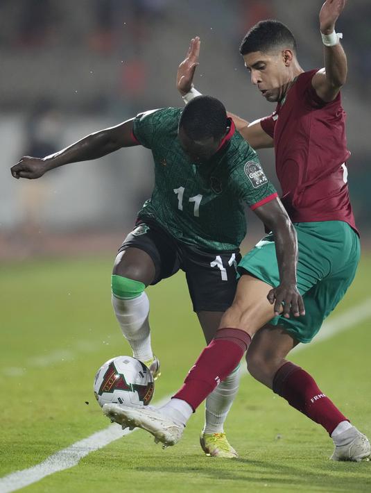 Penyerang Malawi Gabadinho Mhango berebut bola dengan bek Maroko Adam Masina pada babak 16 besar Piala Afrika 2021 di Ahmadou Ahidjo Stadium, Yaounde, Rabu (26/1/2022) dini hari WIB.  Achraf Hakimi menjadi penentu kemenangan Maroko atas Malawi, 2-1. (AP Photo/Themba Hadebe)