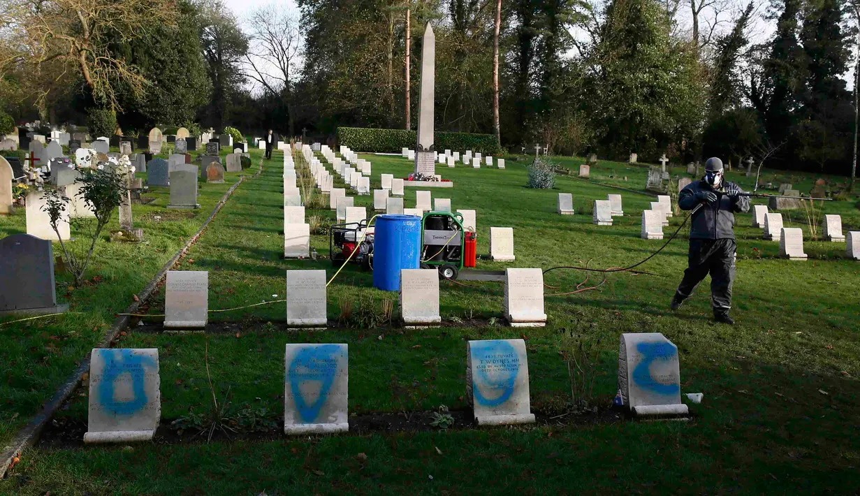 Pekerja bersiap membersihkan batu nisan kuburan Harefield di Hillingdon, Inggris, Rabu (23/11). Kuburan prajurit Australia & New Zealand yang tewas pada Perang Dunia I dicoret dengan graffiti kedua kalinya dalam 7 bulan terakhir. (REUTERS/Stefan Wermuth)