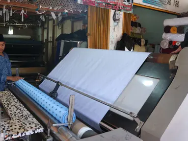 Pekerja tengah menggulung bahan di Pasar Cipadu, Tangerang, Selasa (30/8).Dirjen Industri Kimia, Tekstil, dan Aneka (IKTA) Kemenperin optimistis kinerja industri tekstil dan produk tekstil nasional akan gemilang. (Liputan6.com/Angga Yuniar)