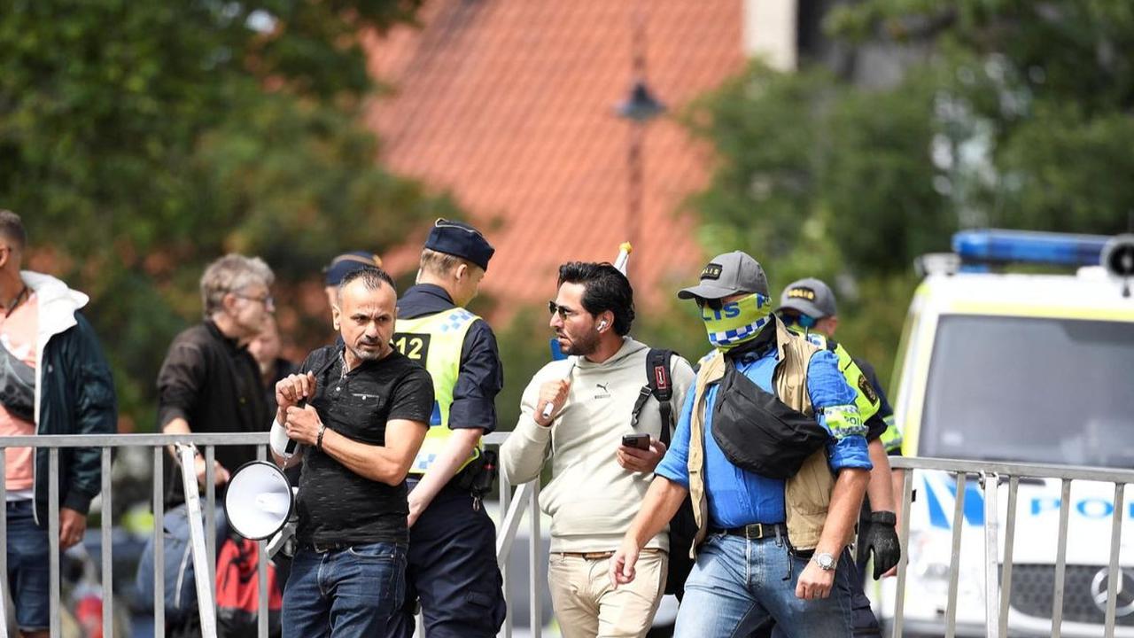 Salwan melakukan aksi tersebut besama seorang rekannya. Mereka tampak berjalan ke lokasi protes dengan pengawalan polisi.