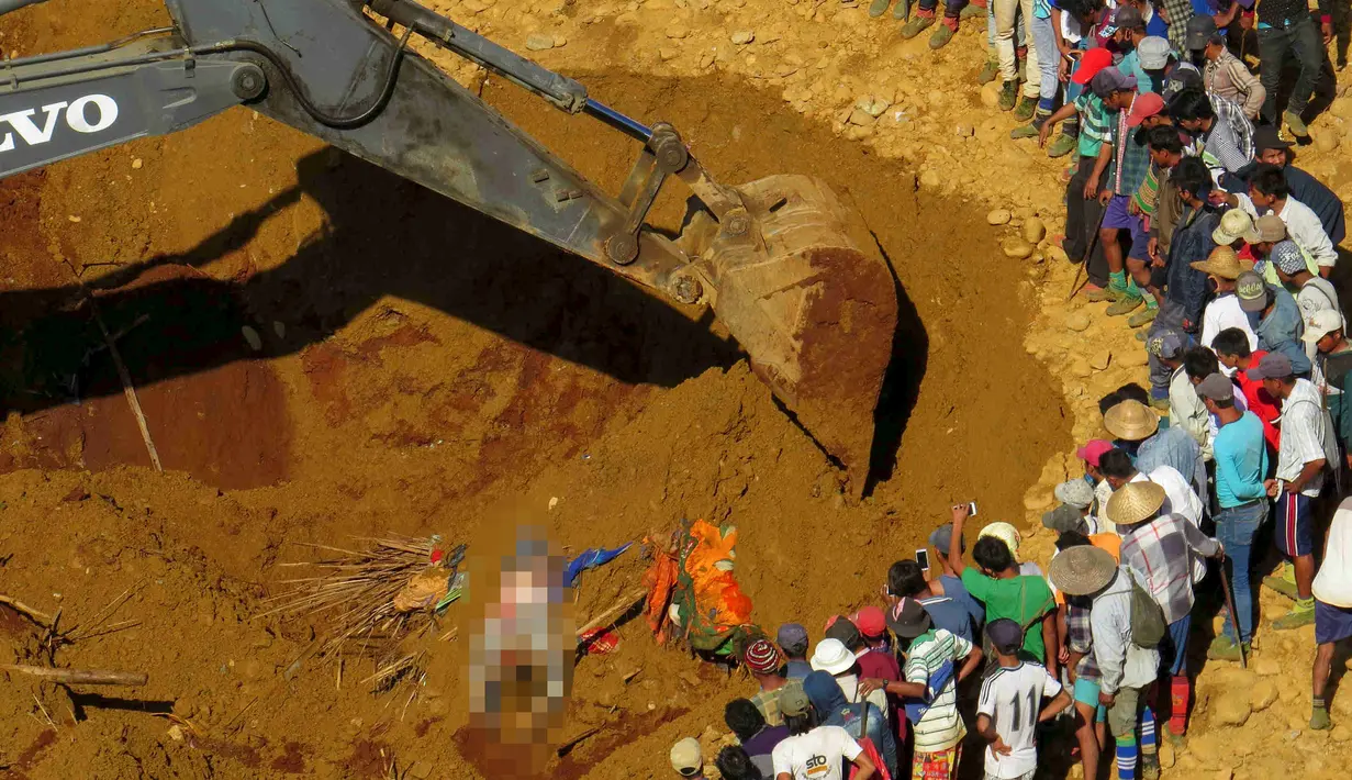 Petugas penyelamat saat mencari para korban longsor ditumpukan tanah di lokasi tambang Hpakant giok, Myanmar, (21/11). Longsor terjadi disebuah perkemahan kumuh yang berada tepat disebelah pertambangan. (REUTERS/Stringer)