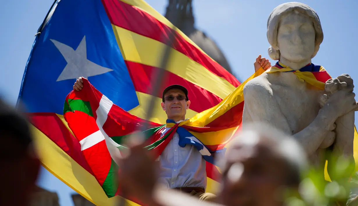 Seorang pria mengangkat tangannya saat berpartisipasi dalam aksi menuntut kemerdekaan Catalonia, di Barcelona, Minggu (11/6). Catalonia secara sepihak merencanakan menggelar referendum untuk berpisah dari Spanyol pada 1 Oktober. (AP/Emilio Morenatti)